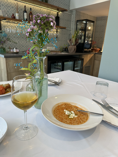 Trachanas tomato soup with crumbled feta and a glass of white wine at Cookaki Athens